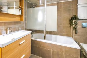 une salle de bain avec une baignoire blanche et un lavabo dans l'établissement Apt 6 Guests Charme Opera de Paris, à Paris