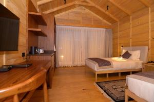 a bedroom with a bed and a desk in a room at Gangtey Pinewood Resort in Gangtey Gonpa