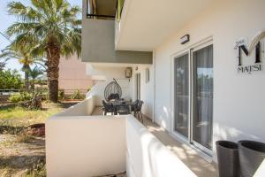 a white building with a table on a patio at Matsi Suites in Faliraki