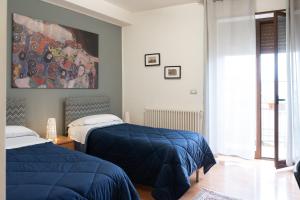 sypialnia z 2 łóżkami i obrazem na ścianie w obiekcie B&B Bella Vista w mieście Valguarnera Caropepe