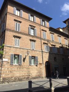 a large brick building with people walking in front of it at Casalbergo in Siena