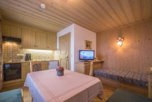 a kitchen with a table and a tv in a room at Ferienwohnungen Egger in Fügen
