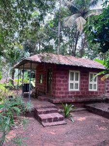 a small red brick house with a porch at Atithi Parinay Homestay in Ratnagiri