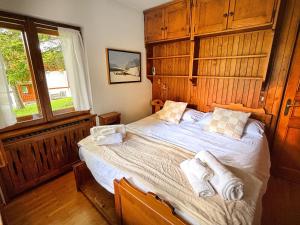 a bedroom with a bed with towels on it at Large Central Flat, 5min to Sky Slopes, Garage in Cortina dʼAmpezzo +19 photos