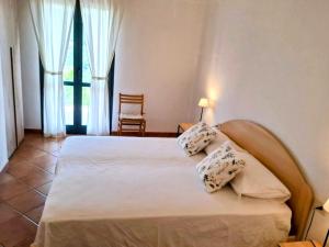 a bedroom with a bed with two pillows on it at Appartamento in villa Porto Pollo in Porto Pollo