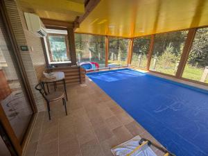 a large swimming pool with a blue floor in a room at Vila Tisina Sarajevo in Nišići