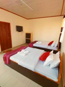two twin beds in a room with a tv at Hindustan Clouds resort in Cherrapunji