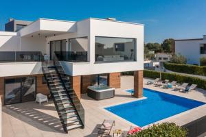 a house with a spiral staircase and a swimming pool at Villa Old Olive IV - Heated Pool - by Vivi Rent in Vodnjan