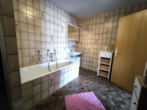 a bathroom with a tub and a sink at Haus Amalie in Bad Hindelang