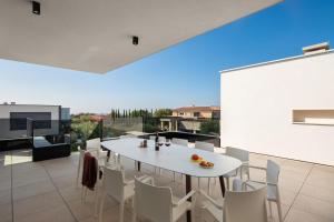 a white dining room with a white table and chairs at Villa Old Olive IV - Heated Pool - by Vivi Rent in Vodnjan