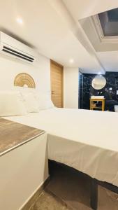a white bed in a room with a table at L'appart Cassis in Cassis