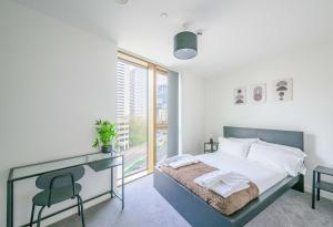 a bedroom with a bed with a desk and a window at Spacious 1 Bedroom Apartment in Central Birmingham in Birmingham