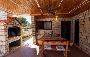 un patio extérieur avec une cheminée en pierre et un ventilateur de plafond dans l'établissement Villa Jadranka by Villas Guide, à Otočić Ošjak