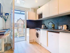 a kitchen with a washer and dryer at Suite Street Art - Appartement central in Argenteuil