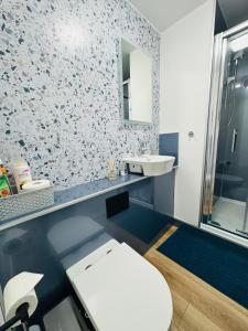 a bathroom with a white toilet and a sink at EVELYN - KENILWORTH STUDIO FLAT 30m2 - PRIVATE PARKING in Kenilworth
