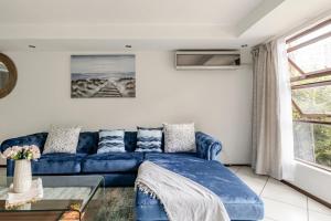 a blue couch in a living room with a window at 3bed luxury apartment sandton city in Johannesburg +37 photos