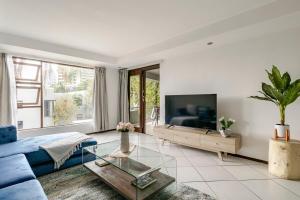 a living room with a blue couch and a tv at 3bed luxury apartment sandton city in Johannesburg