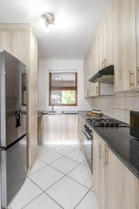 a large kitchen with wooden cabinets and black counter tops at 3bed luxury apartment sandton city in Johannesburg
