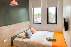 GeruntangSans Stay Eskole Lampung的带一张床和两扇窗户的卧室