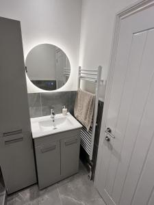 a white bathroom with a sink and a mirror at Dine with the Sunset - Central Folkestone Gem in Folkestone +13 photos