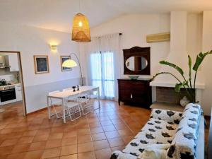 a living room with a couch and a table at Appartamento in villa Porto Pollo in Porto Pollo