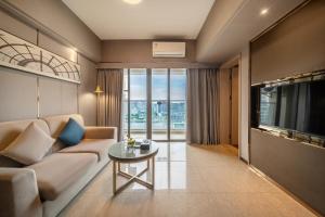 a living room with a couch and a tv at Foshan Poltton International Serviced Apartment-Canton fair free shuttle bus in Foshan