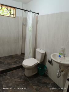 a bathroom with a toilet and a sink at Finca Arcanos Celeste in Barbosa