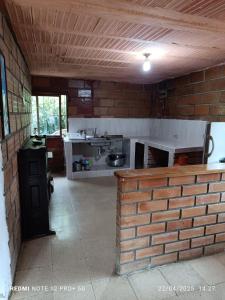 a kitchen with a brick wall in a room at Finca Arcanos Celeste in Barbosa