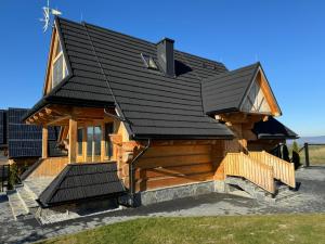 a log cabin with a black roof at Pikno Chata PL in Biały Dunajec