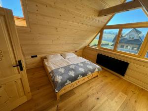 a bed in a room with a large window at Pikno Chata PL in Biały Dunajec