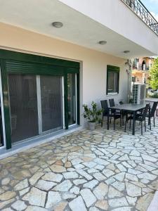 een patio met een tafel en stoelen erop bij Ammouses Apartment in Potamós