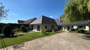 ein Haus mit einem schwarzen Dach und einer Auffahrt in der Unterkunft Appartement cosy + accès jardin et salle de muscu in Mardié