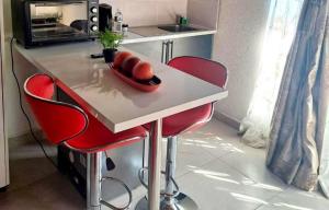 a kitchen counter with two red chairs and a table with two balls at C-rane guesthouse in Phalaborwa