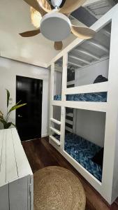 a bedroom with bunk beds with a ceiling fan at Ying Yang House Catangnan in General Luna