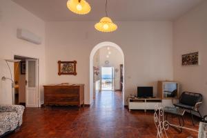 a living room with an archway and a couch and a television at Casa sul Mare by Rentbeat in Vieste