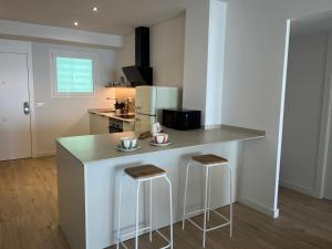 a kitchen with a counter and two stools in it at Salou SEA SUNSET in Salou +13 photos