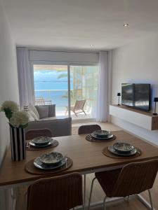 a living room with a table and chairs with a view of the ocean at Salou SEA SUNSET in Salou