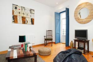 a living room with a table and a tv at Magnificent Historical City Centre Apart with Terrace in Lisbon