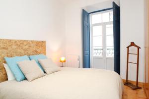 リスボンにあるMagnificent Historical City Centre Apart with Terraceのベッドルーム1室(青と白の枕が備わるベッド1台付)