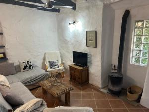 a living room with a couch and a tv at Casa rural La Bodega in Castell de Ferro