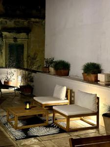 Poolside Paradise in Puglia - Il Dolce di Lecce في ليتشي: فناء مع كراسي وطاولات ونباتات الفخار