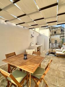 Poolside Paradise in Puglia - Il Dolce di Lecce في ليتشي: غرفة طعام مع طاولة وكراسي خشبية