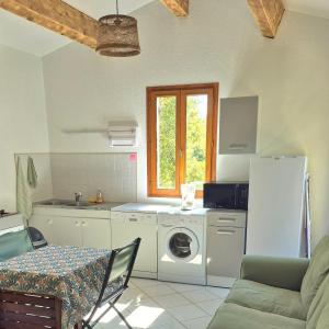 Una cocina con lavadora y secadora en una habitación. en Maison indépendante avec Jardin, Studio de 26m2 tout équipé avec Climatisation réversible, en Rochegude