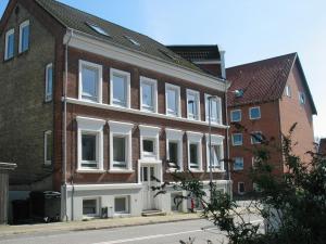 a large brick building with white windows on a street at Aalborg City Rooms ApS in Aalborg