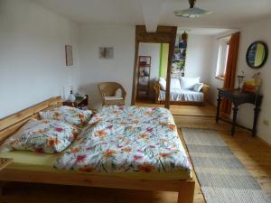 a bedroom with a bed with a floral comforter at Upcycling Ferienhaus in Roth