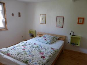 a bedroom with a bed with a floral comforter at Upcycling Ferienhaus in Roth