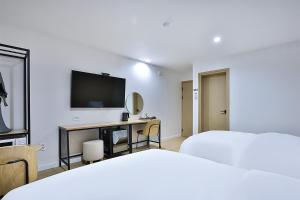 a hotel room with a bed and a television at Brown Dot Gumi Okgye in Gumi