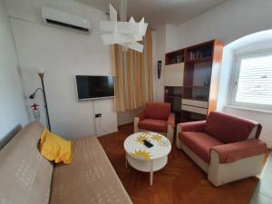 a living room with a couch and two chairs and a table at Apartment Goga in Cres