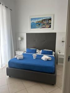 a bedroom with a blue bed with two towels at Coral Blue Apartment in Piano di Sorrento