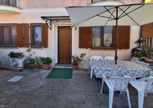 une table avec un parasol devant une maison dans l'établissement Casa Silvana Relax e Mare nel cuore di Sant'Antioco, à SantʼAntìoco